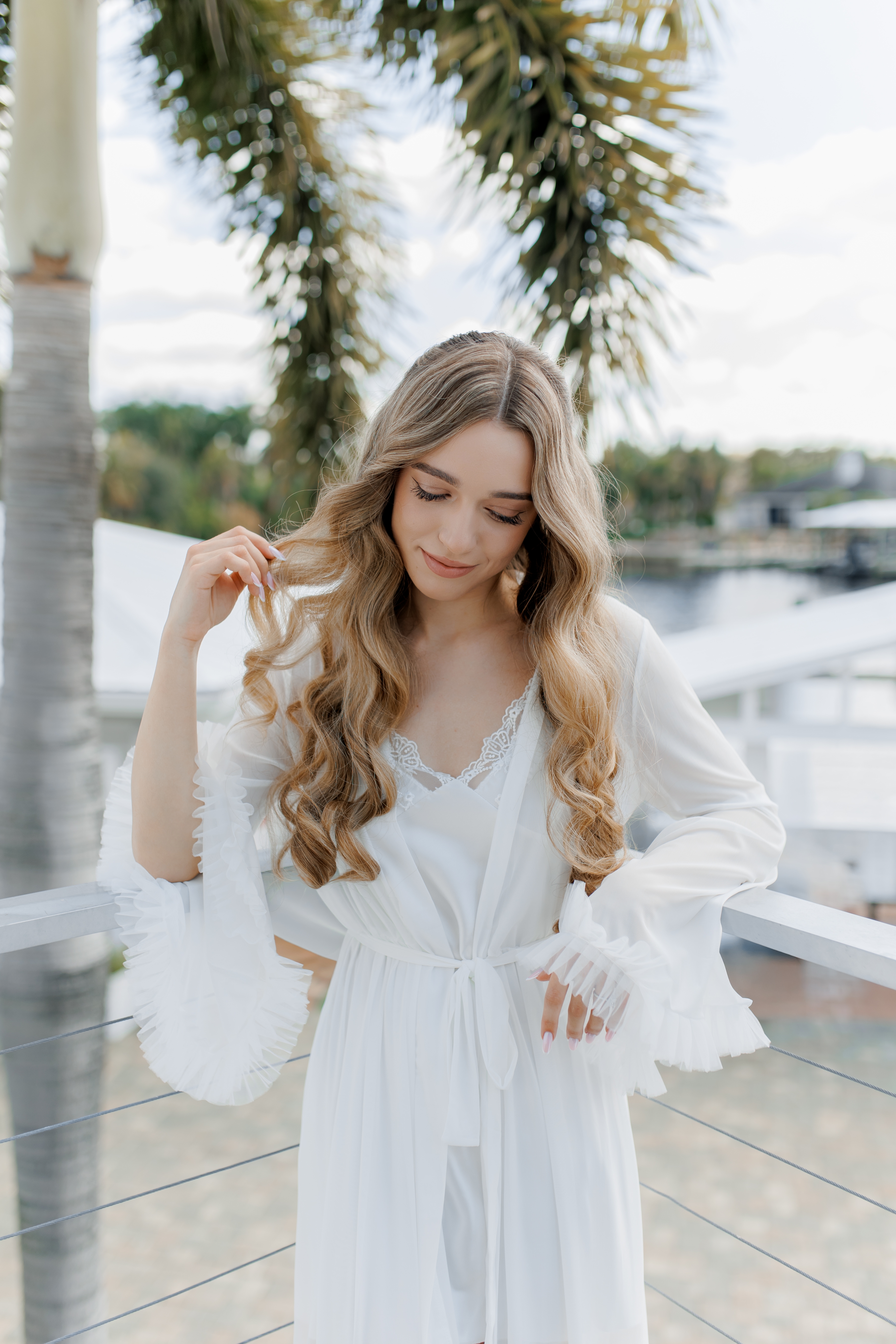 Bride in white robe, waterfront